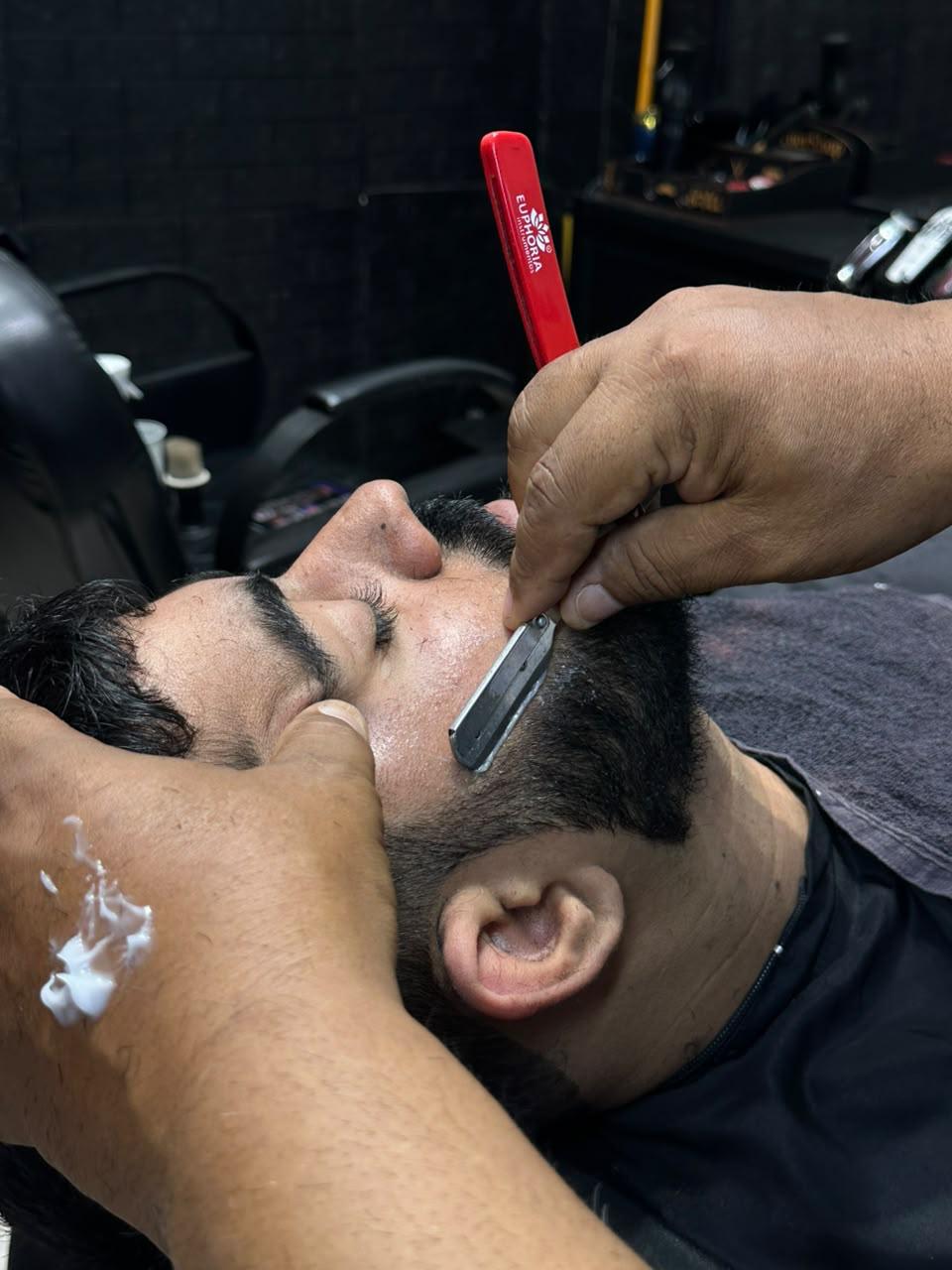 Barbearia em ação, finalizando barba comnavalha